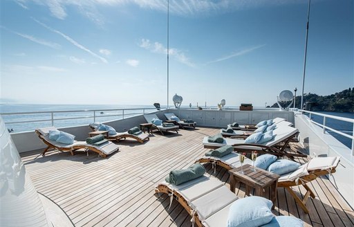 Sunloungers on large teak deck of superyacht Bleu De Nimes