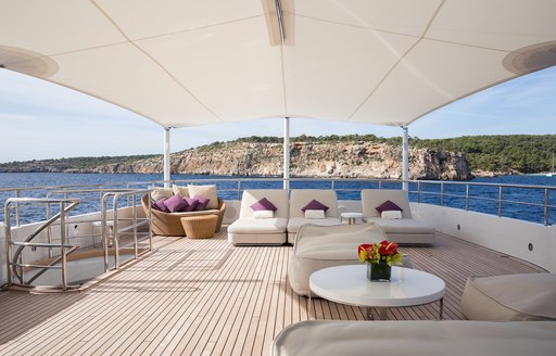 Bimini covers chaise loungers and lounging area on sundeck of luxury yacht GO