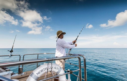 a guest onboard superyacht northern sun enjoying their luxury yacht charter vacation by social distancing away from crowds and deep sea fishing in peace 