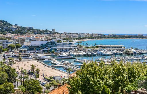 Aerial view looking over the Cannes coastline with many motor yacht charters berthed in marina