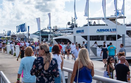 Visitors walking along the dock at FLIBS with superyachts berthed 