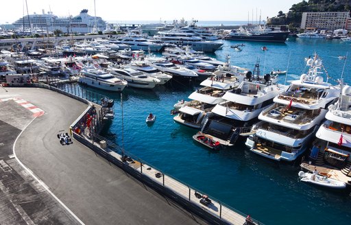 F1 car on the circuit during Monaco Grand Prix, tearing past yachts in the marina