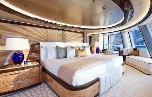 Master cabin onboard superyacht charter EXCELLENCE, central berth surrounded by glazing