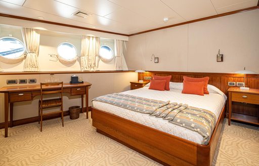 Guest cabin onboard charter yacht ASTERIA with central double berth and porthole windows