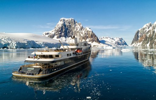 Charter yacht AQUA LARES underway surrounded by snowy peaks