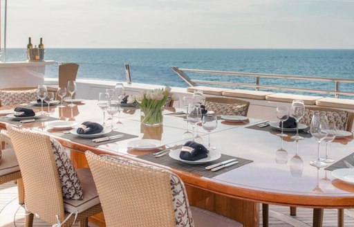 al fresco dining and wet bar in background of superyacht oasis