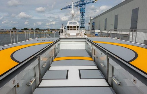 Helipad on Game Changer yacht with crane in background