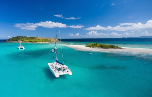 luxury catamaran on a private charter anchors at Sandy Spit in the British Virgin Islands