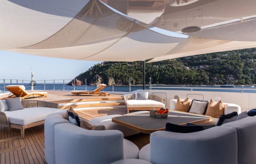 Alfresco lounge area with sofas and coffee tables onboard charter yacht LADY A