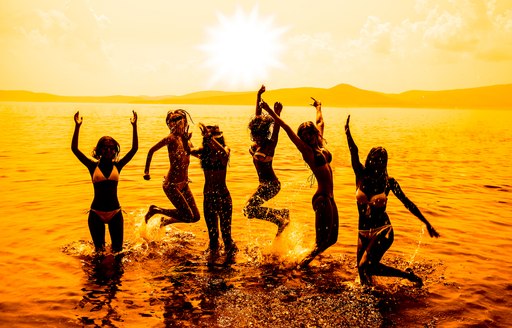 Young people silhouetted against a setting sun in Ibiza