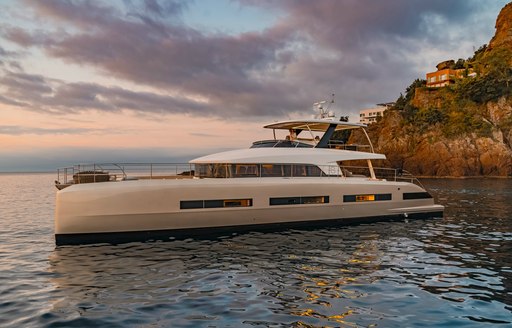 Luxury yacht Double Down profile shot against setting sun 