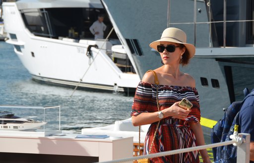 Well-dressed woman poses on yacht at boat show in Cannes