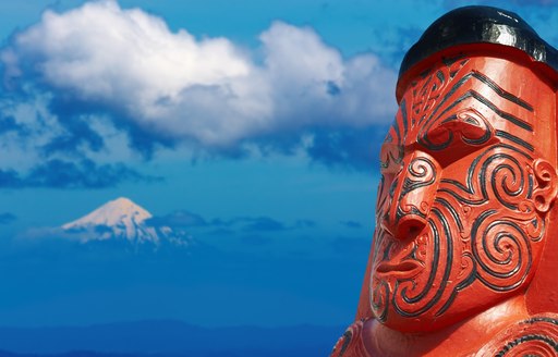 Traditional maori carving over Taranaki Mount background, New Zealand