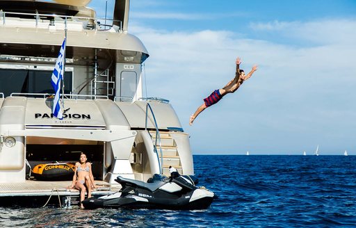 Charter yacht PANDION with charter guest diving off deck