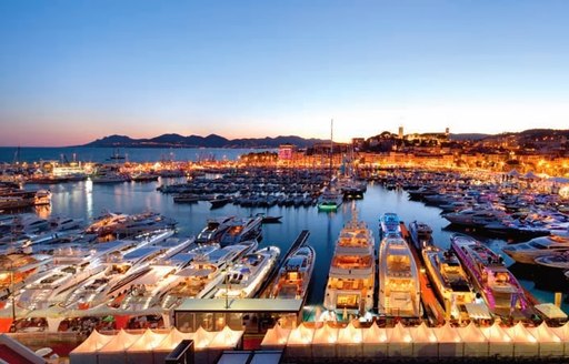 A collection of yachts berthed in Cannes at night for the film festival