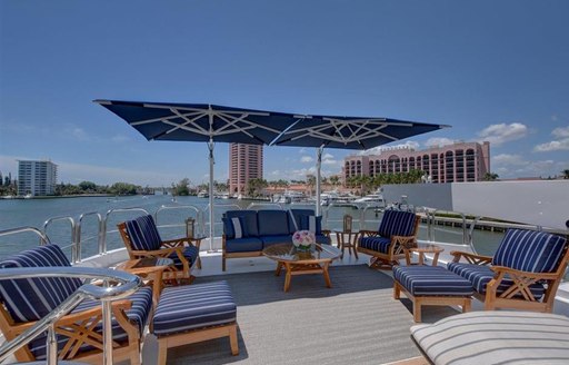 Sun deck with sun loungers aboard luxury yacht AQUASITION with Floridian skyline