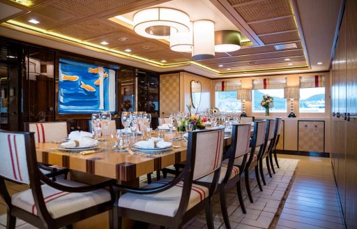 Interior dining area onboard charter yacht AXIOMA with long table