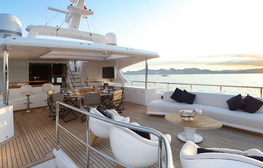 alfresco dining table and seating area on the upper deck aft of luxury yacht URIAMIR 