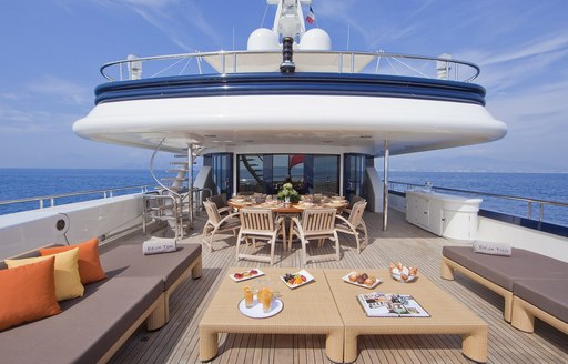 alfresco dining area and seating on the upper deck aft of luxury yacht Deja Too