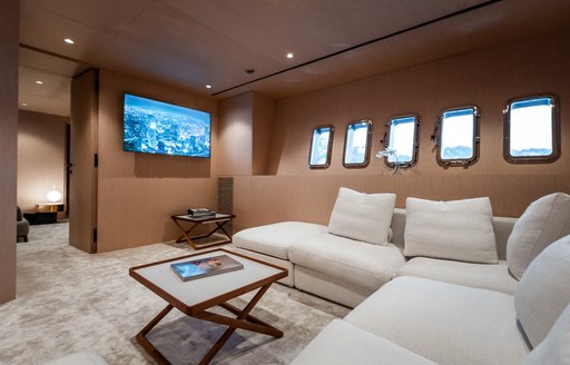 Sofa and table with TV on wall of charter yacht NEOPRENE