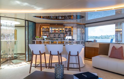 Interior wet bar with three white stools onboard charter yacht ETERNAL SPARK