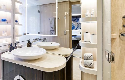 en suite bathroom on charter yacht soaring, with cream coloured sink and shelves