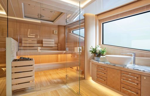 Overview of the sauna onboard superyacht charter EXCELLENCE with a wide window in the foreground