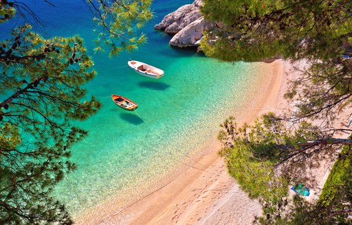 Hiden beach in Brela with boats on emerald sea aerial view, Makarska riviera of Dalmatia, Croatia