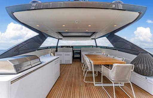 Flybridge with dining table and chairs onboard superyacht charter NOTYNOG