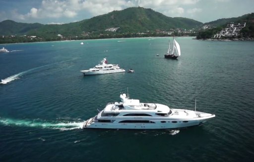 A collection of superyachts cruising close to the Kata Rocks Resort in Phuket, Thailand