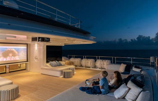 Exterior cinema setup onboard charter yacht STARBURST IV with two charter guests watching a movie