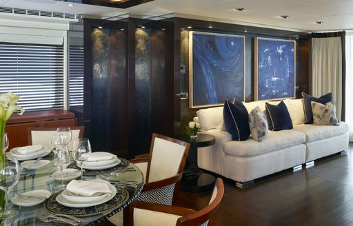 glass-topped dining table and cream sofa in the main salon aboard superyacht ROCKET 