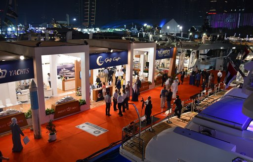 yachts and exhibitors in the marina at the Dubai International Boat Show at night