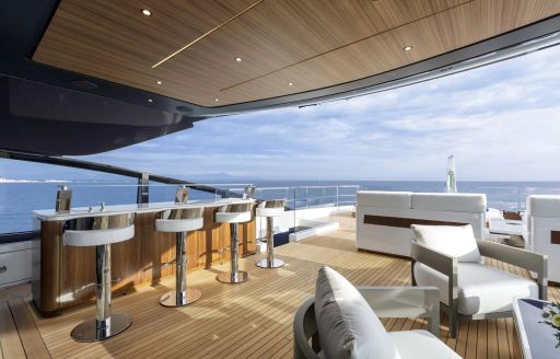 Charter yacht SHE'S A 10 TOO exterior seating with wet bar and stools