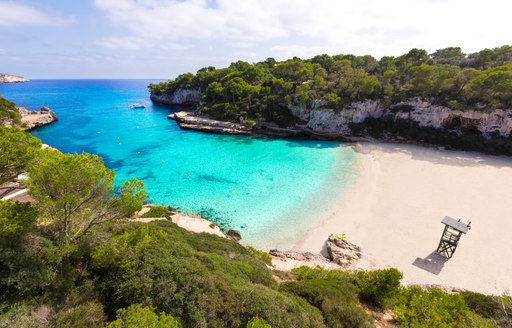 sandy beach in menorca with bright blue ocean