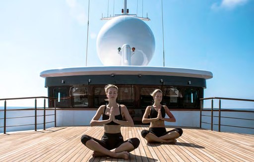 Couple doing yoga in open air on deck of Superyacht CHAKRA