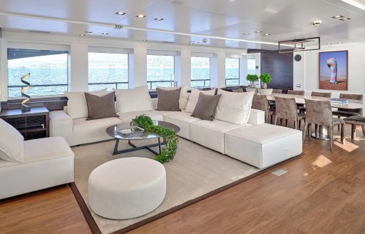 Main salon onboard charter yacht AFRICA I, lounge area in the foreground with dining aft