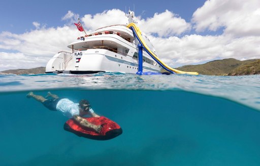 A man dives with a seabob, with MY Flag in the distance