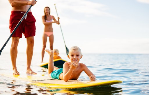 Family Having Fun Stand Up Paddling Together in the Ocean on Beautiful Sunny Morning