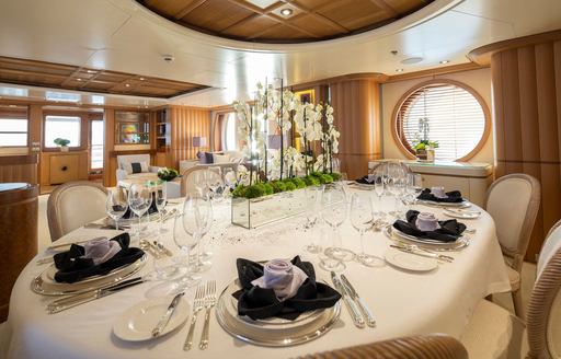 Interior dining area with round table set for a meal onboard luxury yacht rental MARLA