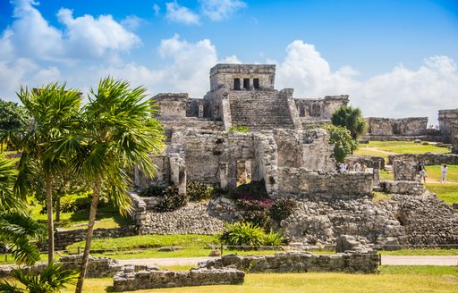 mayan ruins in mexico, with palm trees in foreground