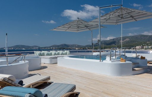 chaise loungers and sun pad surround swimming pool on sundeck of luxury yacht BOADICEA 