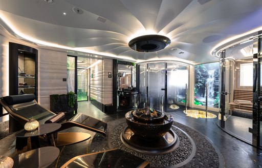 Spa area onboard superyacht charter KISMET with black and gold decor and entrances to a sauna and steam room