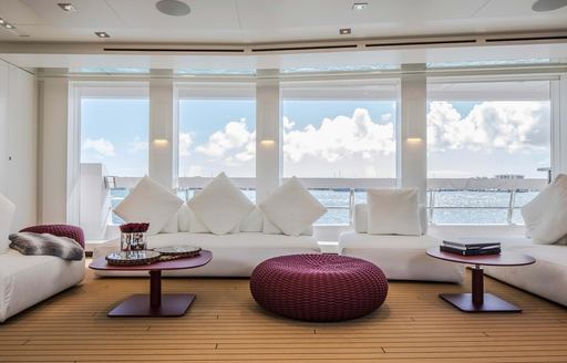 the luxurious seatig arrangement inside the upper deck salon of charter yacht home overlooking the Caribbean water 