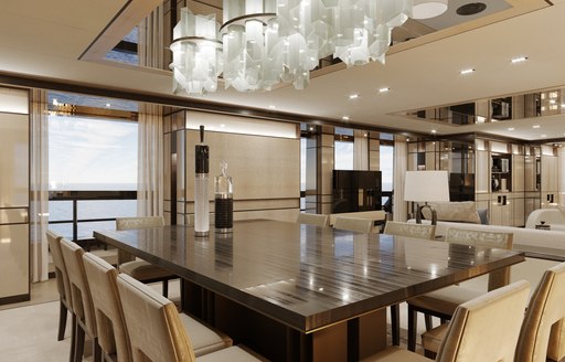 Dining area onboard charter yacht RELIANCE. Large dining table with cream chairs adjacent to full length window.