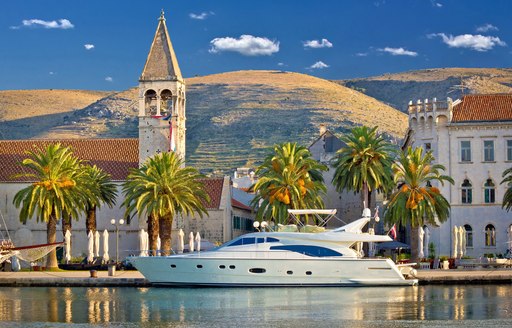 a motor yacht against a view of Croatia