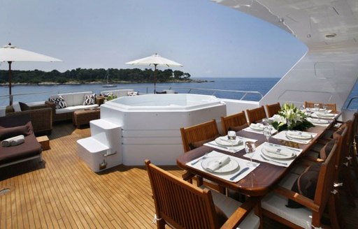 Sundeck dining area and jacuzzi on charter yacht daydream