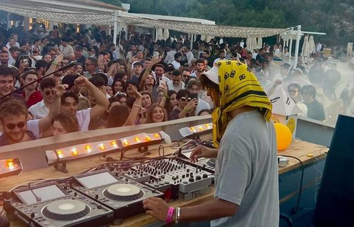 DJ in action with large crowd at Lucca Beach