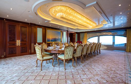 Formal dining area with long table and large window onboard charter yacht BLACK PEARL