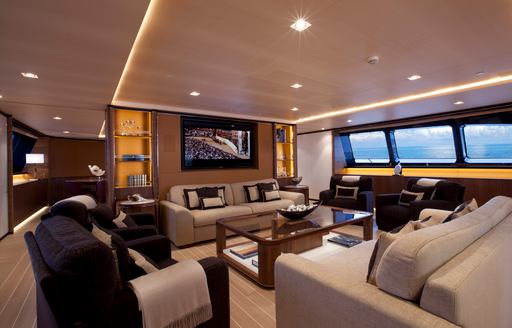 Main salon on sailing yacht Fidelis, with sofas facing a TV and windows